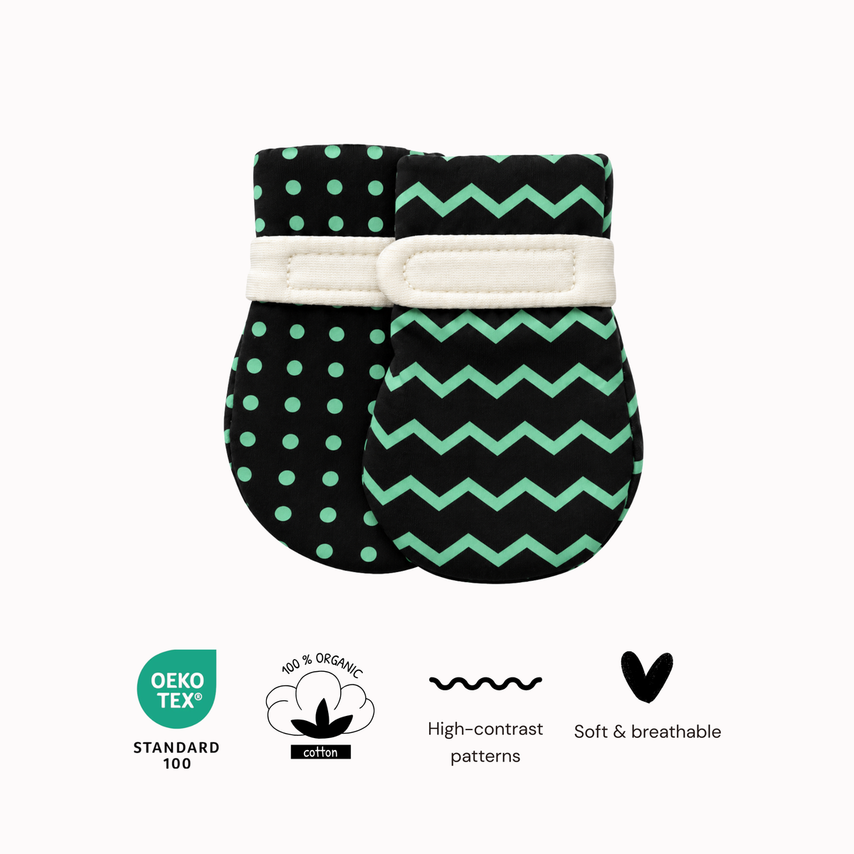 Two high-contrast baby mittens with visual patterns, one with green polka dots and the other with a green chevron, featuring a white elastic band. Below the products are four circular and text badges indicating Oeko Tex Standard 100, 100% Organic Cotton, high-contrast patterns, and soft & breathable material.