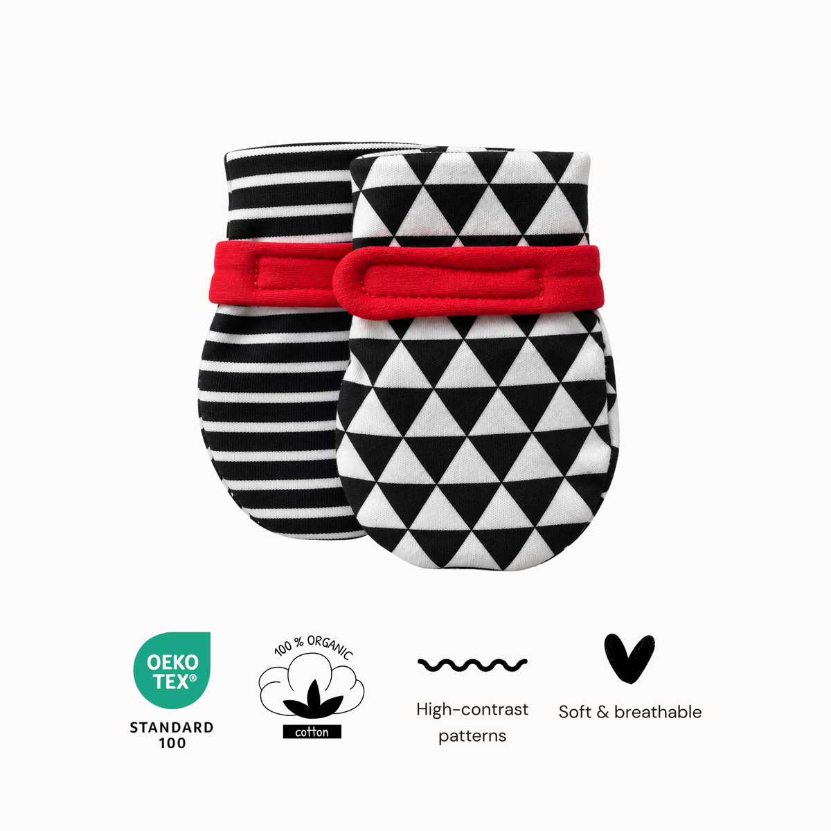 Two baby mittens with black and white patterns and a red elastic band, shown on a light gray background with feature icons and Oeko-TEX 100 / 100% Organic Cotton badges below.