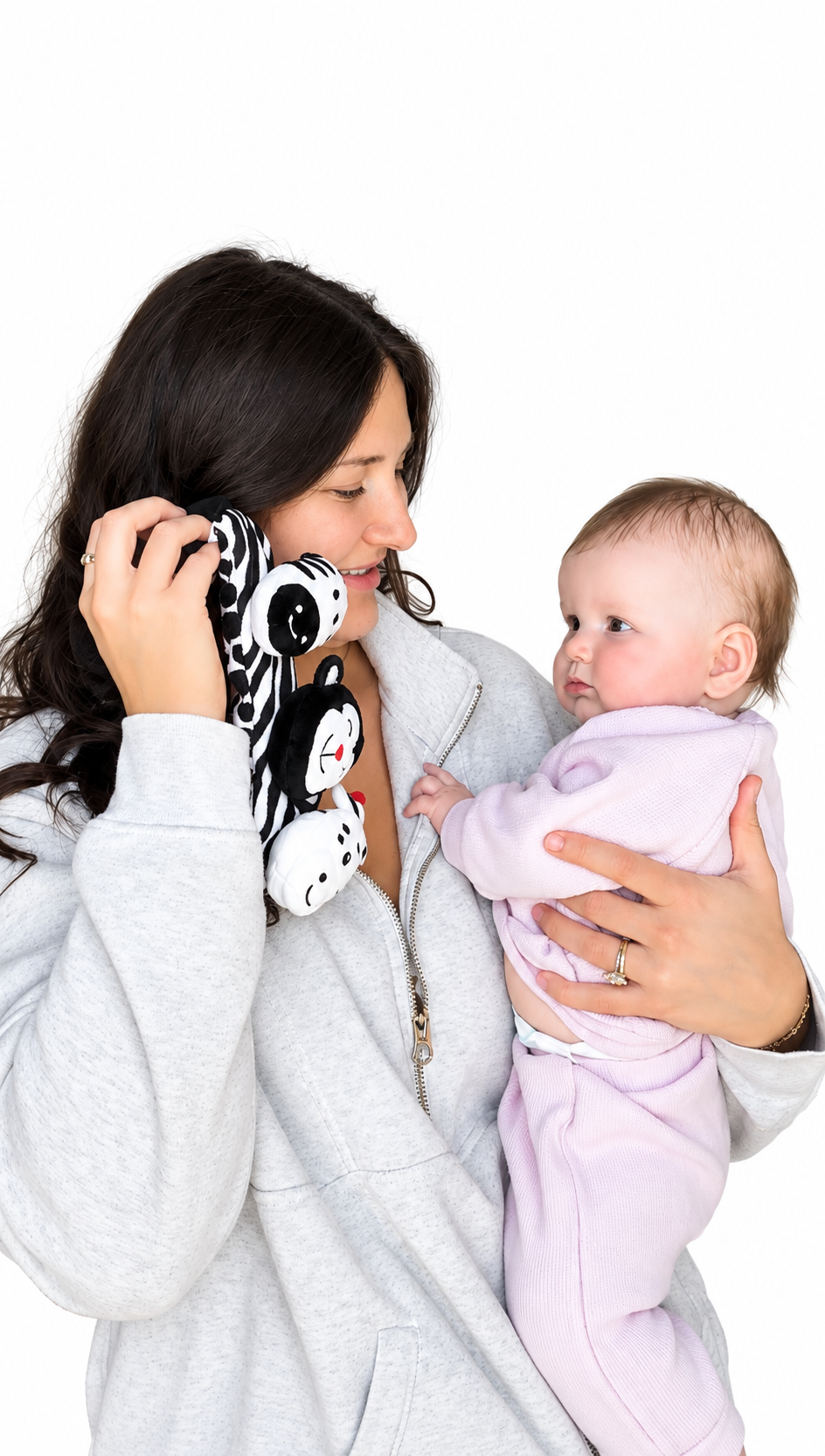 a mom holding looky baby the high-contrast sensory headband designed by an occupational therapist for newborns to encourage visual development and engagement. it is a caregiver-worn baby distraction headband for diaper changes and daily routines. the headband is made of soft fabric with black and white  patterns and animal characters to grab a baby's attention. the baby is looking at the headband and smiling. 