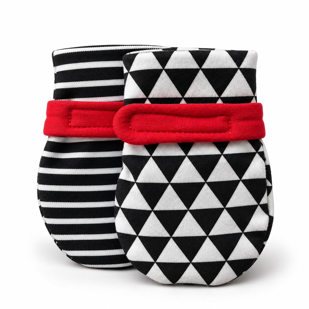Two baby mittens on a white background, one with a black and white striped pattern and a red band, and the other with a black and white triangle pattern and a red band. soft baby mittens for visual tracking and hand discovery. 