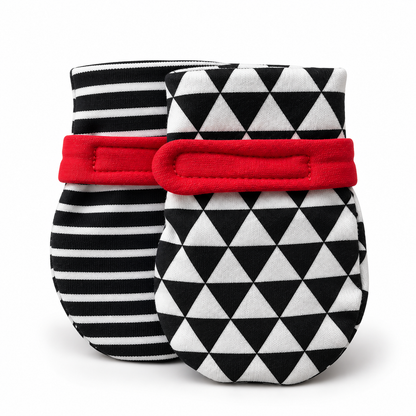 Two baby mittens on a white background, one with a black and white striped pattern and a red band, and the other with a black and white triangle pattern and a red band. soft baby mittens for visual tracking and hand discovery. 