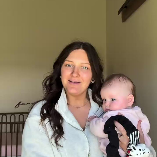 mom talking about the looky baby high contrast sensory toy while holding her baby 