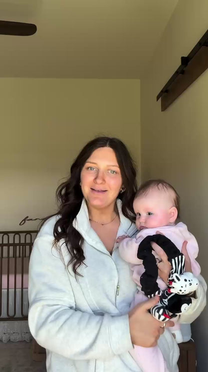 mom talking about the looky baby high contrast sensory toy while holding her baby 