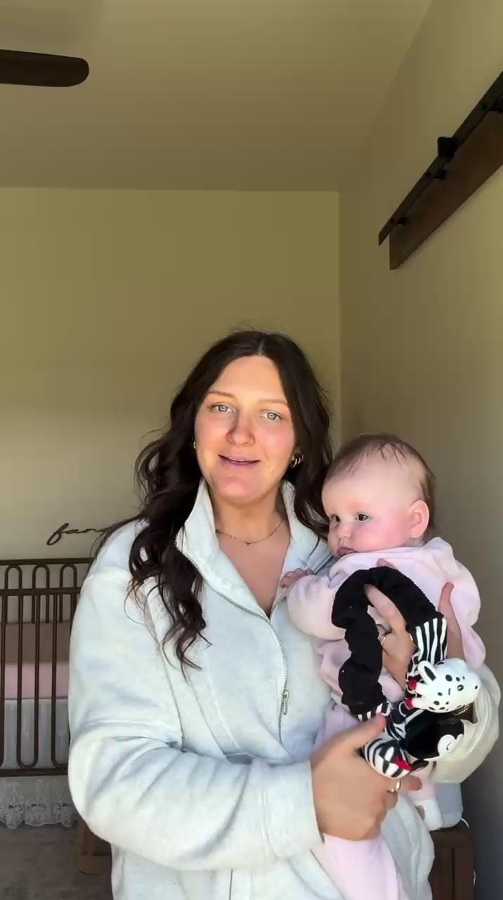 mom talking about the looky baby high contrast sensory toy while holding her baby 
